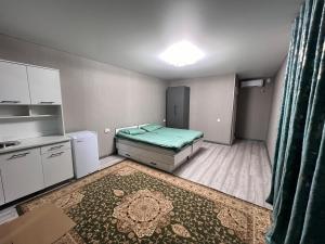a small room with a bed and a kitchen at Tims house in Karakol +3 photos