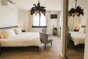 a hotel room with two beds and a couch at Coucou - luxe bed and breakfast in Wenduine +14 photos