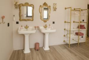 a bathroom with two sinks and two mirrors at Coucou - luxe bed and breakfast in Wenduine