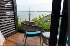 balkon z dwoma krzesłami i widokiem na ocean w obiekcie The Warmly Home w mieście Nam Khê +5 zdjęć