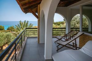 a balcony with two chairs and the ocean at Villa LaThea in Akti Salonikiou
