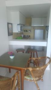 a kitchen with a table and some chairs and a table and a counter at Apart Hotel de Ondina in Salvador