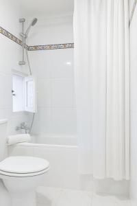 ニハルにあるLa Buganvilla del Pazoのトイレとシャワー付きの白いバスルーム