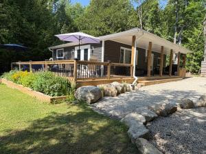 a house with a porch with an umbrella on it at Peninsula Perch in Wiarton