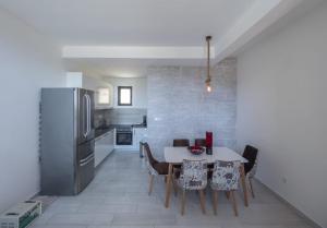a kitchen with a table with chairs and a refrigerator at Seaview Villa with pool-Vanja in Budva