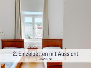 a bedroom with two beds and a window at Salzkammergut Homes Gmunden - Suite Marie Antoinette, Blick auf den Stadtplatz, Traunseeblick - ideal für Paare und Kulturinteressierte in Gmunden