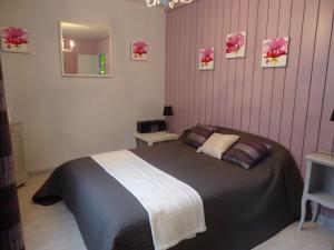 Un dormitorio con una cama grande con rayas rosas. en Chalet Vert 10 min walk to Argentat city center, en Argentat