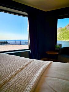 Un dormitorio con una cama y vista al mar. en Ocean panorama, en Senja