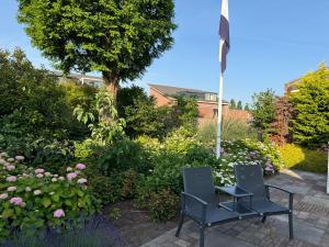 two chairs and a flag in a garden at Maison Lelystad in Ons Belang