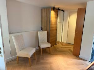 a hallway with two chairs and a closet at Maison Lelystad in Ons Belang +9 photos
