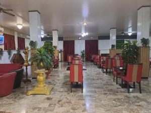 a dining room with tables and chairs and plants at Hotel Paradiso in Castelfranco Emilia