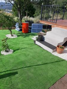 a yard with green artificial grass and a staircase at AGRO da FONTE- Apartamento in Muros