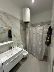 a white bathroom with a sink and a toilet at Exlusive Home Golem in Golem +26 photos