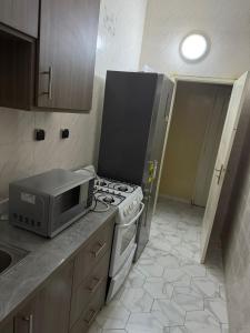 a kitchen with a stove and a microwave at Zac B Hosting in Mbaw +8 photos