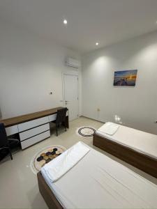 a bedroom with two beds and a desk in it at Exlusive Home Golem in Golem