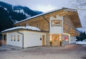 a house with a garage in the snow at Appartement Wimreiter in Saalbach Hinterglemm