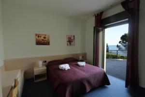 una camera da letto con un letto e due asciugamani di Hotel Aquavite a Gardone Riviera