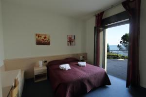ein Schlafzimmer mit einem Bett, auf dem zwei Handtücher liegen in der Unterkunft Edonè Al Lago in Gardone Riviera