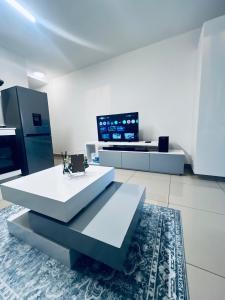 Una sala de estar con una mesa y un televisor. en The 526 Millennial Umhlanga Coup, en Durban