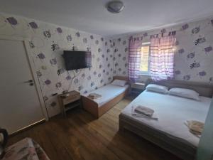 a bedroom with two beds and a tv on the wall at Mihalkat Old Town in Sozopol