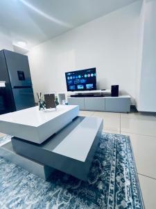 Una sala de estar blanca con una mesa y un televisor. en The 526 Millennial Umhlanga Coup, en Durban 11 fotos más