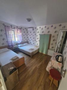 a small room with two beds and a table at Mihalkat Old Town in Sozopol +6 photos