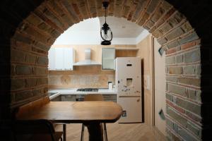 a kitchen with an archway with a table and a refrigerator at Residenza S anna in Rocca Cilento