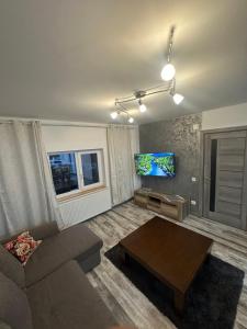 a living room with a couch and a flat screen tv at Azuga Home in Azuga