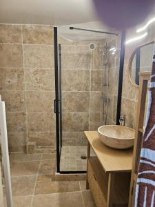 a bathroom with a shower with a sink and a sink at Le petit Vincent, Studio élégant, central avec parking privé in Saint-Rémy-de-Provence