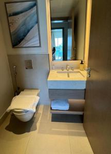 een badkamer met een wastafel, een toilet en een spiegel bij Apartment at Vida Marina Marassi in El Alamein