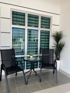a patio with two chairs and a table and a window at DNikayla Homestay in Jitra