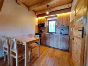 une cuisine et une salle à manger avec une table et des chaises dans l'établissement Bieszczadzki Krakowiak 575-894-584 lub 535-595-732, à Polańczyk