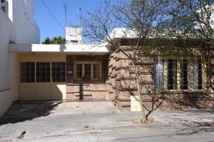 a stone house with a tree in front of it at La casa de Mirta Habitaciones en Córdoba in Cordoba