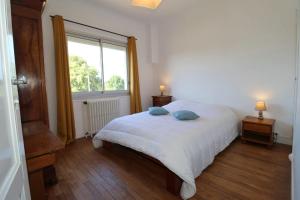 a bedroom with a white bed and a window at L'Escale by Tranquil at Home in Pornichet