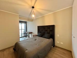 ein Schlafzimmer mit einem großen Bett und einem Tisch in der Unterkunft Departamento en SAN ISIDRO in San Antonio