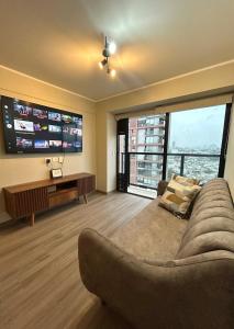 ein Wohnzimmer mit einem Sofa und großen Fenstern in der Unterkunft Departamento en SAN ISIDRO in San Antonio