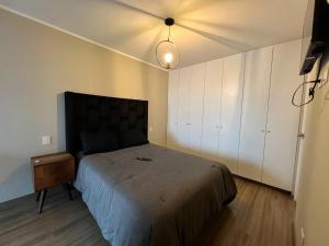 ein Schlafzimmer mit einem Bett, einem Nachttisch und einer Lampe in der Unterkunft Departamento en SAN ISIDRO in San Antonio