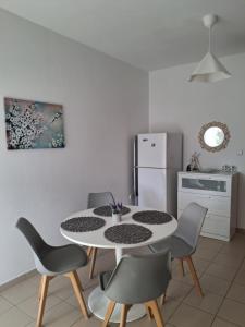 a kitchen with a table and chairs and a refrigerator at Angel's apartments in Panayía