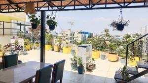 a patio with a table and chairs and potted plants at The Dritan in Bengaluru