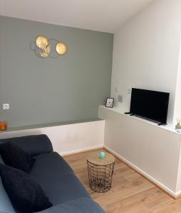 a living room with a couch and a flat screen tv at L escapade pro in La Roche-Chalais