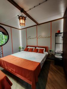 a bedroom with a bed with orange sheets and a chandelier at Qilimcha's Guesthouse & Art-Stay in Telavi +76 photos
