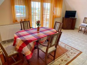 mesa de comedor con mesa a cuadros y sillas en Savelij apartament, en Hévíz