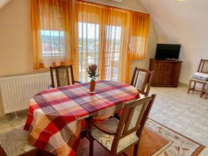 a dining room with a table and chairs and a television at Savelij apartament in Hévíz