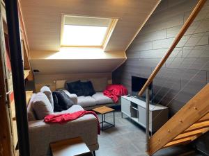 a living room with a couch and a window at La pause Pom' de Pain appartement in Rochehaut