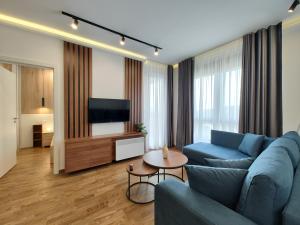 Una sala de estar con un sofá azul y un televisor en Omorika Lux, en Zlatibor