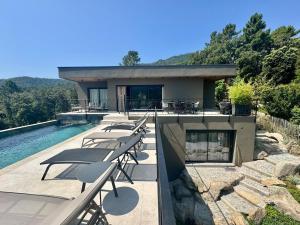 a house with chairs and a swimming pool at Villa neuve perchée - Vue splendide in Zonza