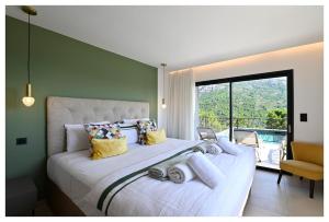 a bedroom with a large white bed with a large window at Villa neuve perchée - Vue splendide in Zonza +40 photos