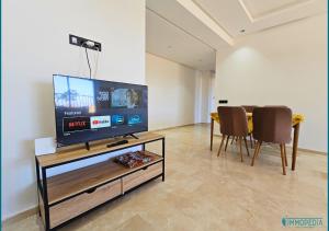 sala de estar con TV de pantalla plana y sillas en Le Refuge Océanique idéal !, en Benslimane