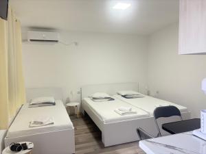 a room with two beds and a table and chairs at TIKI Apartments in Gevgelija +71 photos