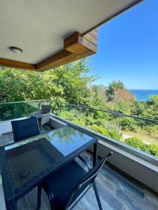 a table and chairs on a balcony with a view of the ocean at Byla Sea side Apartament in Byala